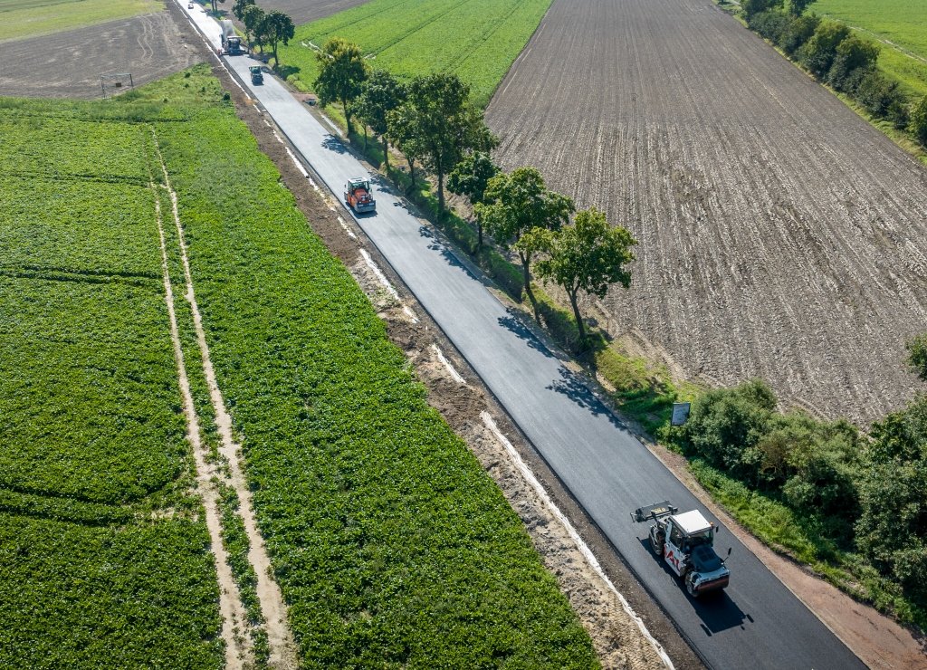 PowiatL's tweet photo. Spółka Strabag rozpoczęła kilkudniowe układanie warstwy wyrównawczej asfaltu na przebudowywanej drodze (2,3 km) #PowiatLeszczynski do Pawłowic. Przy drodze powstaje też ścieżka rowerowa https://t.co/WrPlVGXL6d