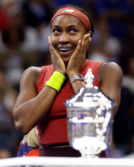 Image: Coco Gauff with her hands on her cheeks and the US Open trophy.