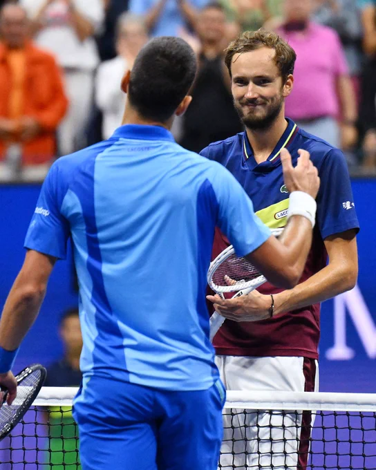 Novak Djokovic and Daniil Medvedev shake hands. 