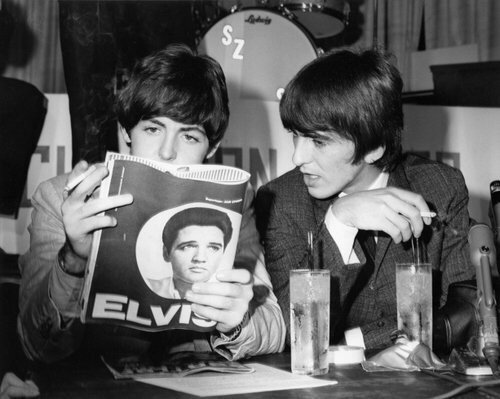 Paul McCartney and George Harrison reading a story on Elvis, 1964