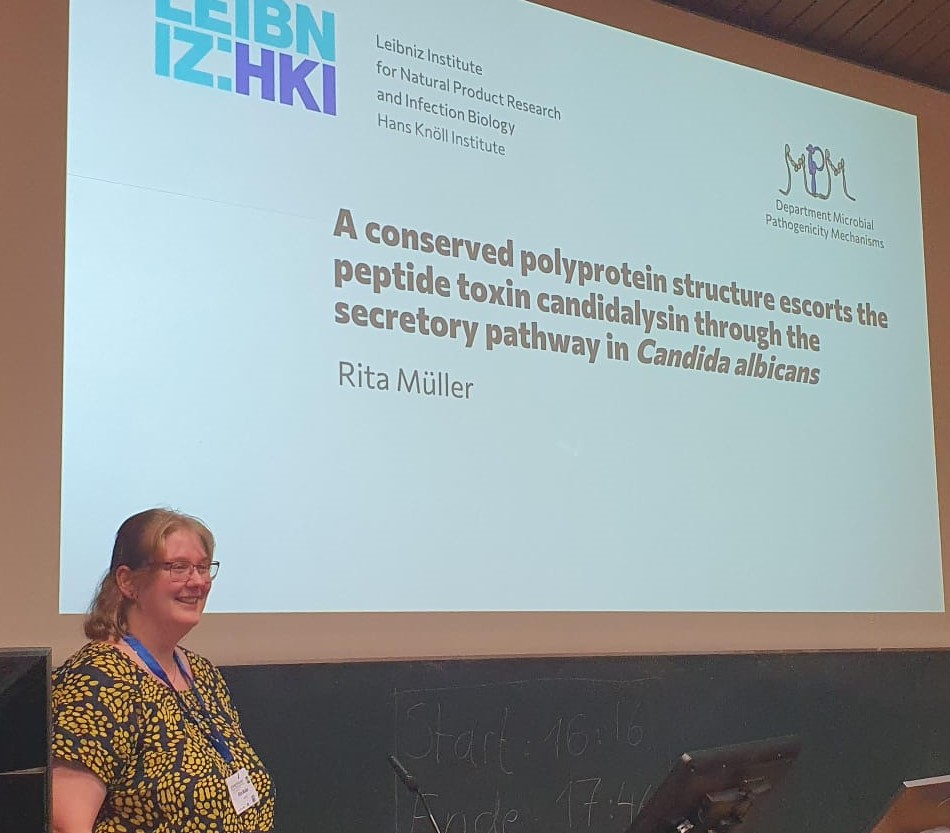 mpm_hki's tweet photo. Our very own Rita Müller presenting her work @VAAM_microbes on how - team work makes the dream work! The conserved polyprotein structure of ece1 helps safely transports the peptide toxin candidalysin out of 𝘊𝘢𝘯𝘥𝘪𝘥𝘢 𝘢𝘭𝘣𝘪𝘤𝘢𝘯𝘴, which helps it establish an infection. https://t.co/rj8hXkuYqH