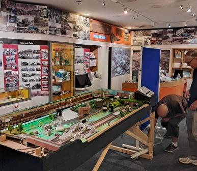 and a working model of the station as it was in 1900 among many other delights.  Our photos show the team hard at work with the new railway layout, and you might spot the Village Hall in the background.  Opening this Saturday at 10 am. See you there!