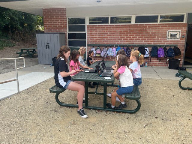 Our 4th graders helping our 1st graders log into their Chromebooks while in our Outdoor Learning space. Cubs helping Cubs - we love to see it! 💚🤗 #AcaciaCubs