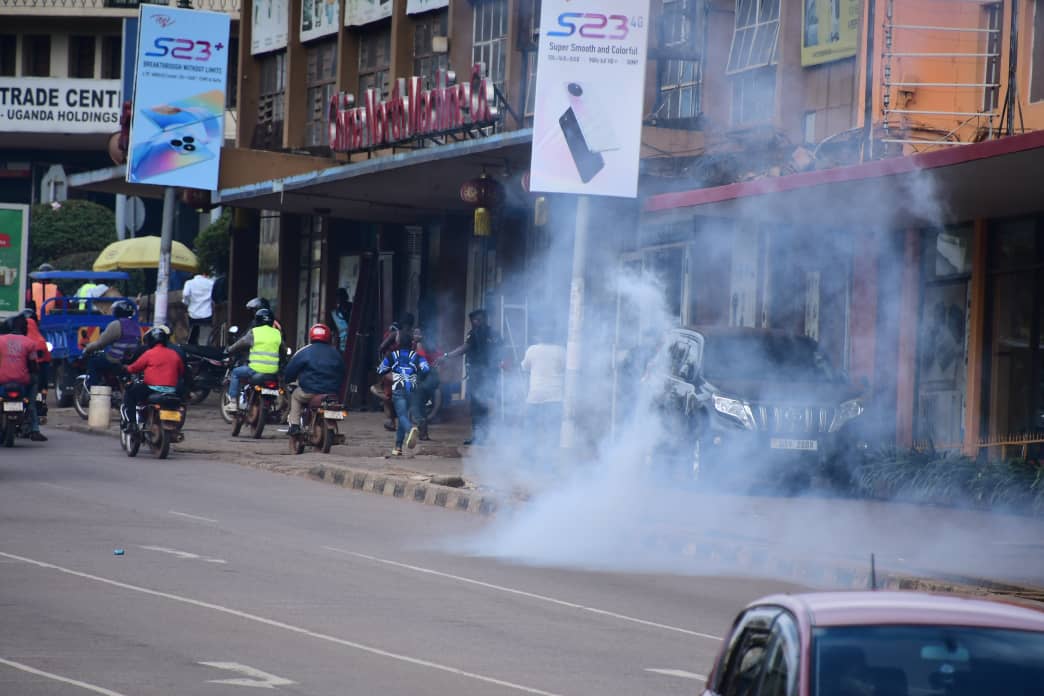 DailyMonitor's tweet photo. Police use tear gas and pepper spray to disperse a group of boda boda riders who had blocked Jinja road traffic lights as they protested the death of their colleague who was crashed by a truck as he reportedly tried to flee from police and KCCA enforcement officers who were running after him. #MonitorUpdates 
📸@abubakerlubowa