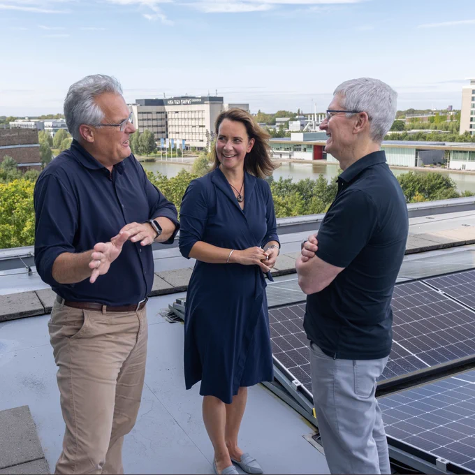 Tim talks with NXP CEO Kurt Sievers and NXP sustainability lead Linda Lengowski on the roof next to a solar panel installation.