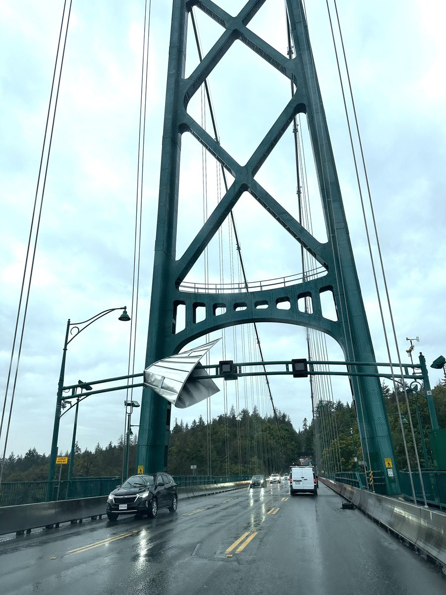 thevanblog's tweet photo. We just crossed the Lions Gate and noticed this large piece of metal dangling. Maybe piece of a truck? Extremely dangerous - esp if there’s a gust of wind coming. @VPDTrafficUnit @CityofVancouver pls remove ASAP https://t.co/wxZn62OWvs