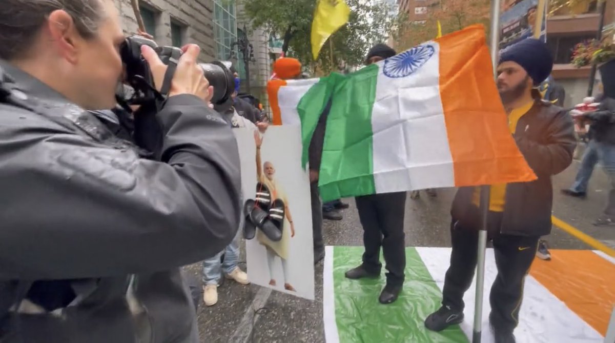 AdityaRajKaul's tweet photo. #BREAKING: Canadian Khalistani radical goons seen here tearing Indian national flag outside the Indian Consulate in #Vancouver. Less than 50 people turned up in the protest call given by designated Khalistani terror group SFJ. Canada remains a mute spectator, facilitating hate. https://t.co/caXWbIQTiR