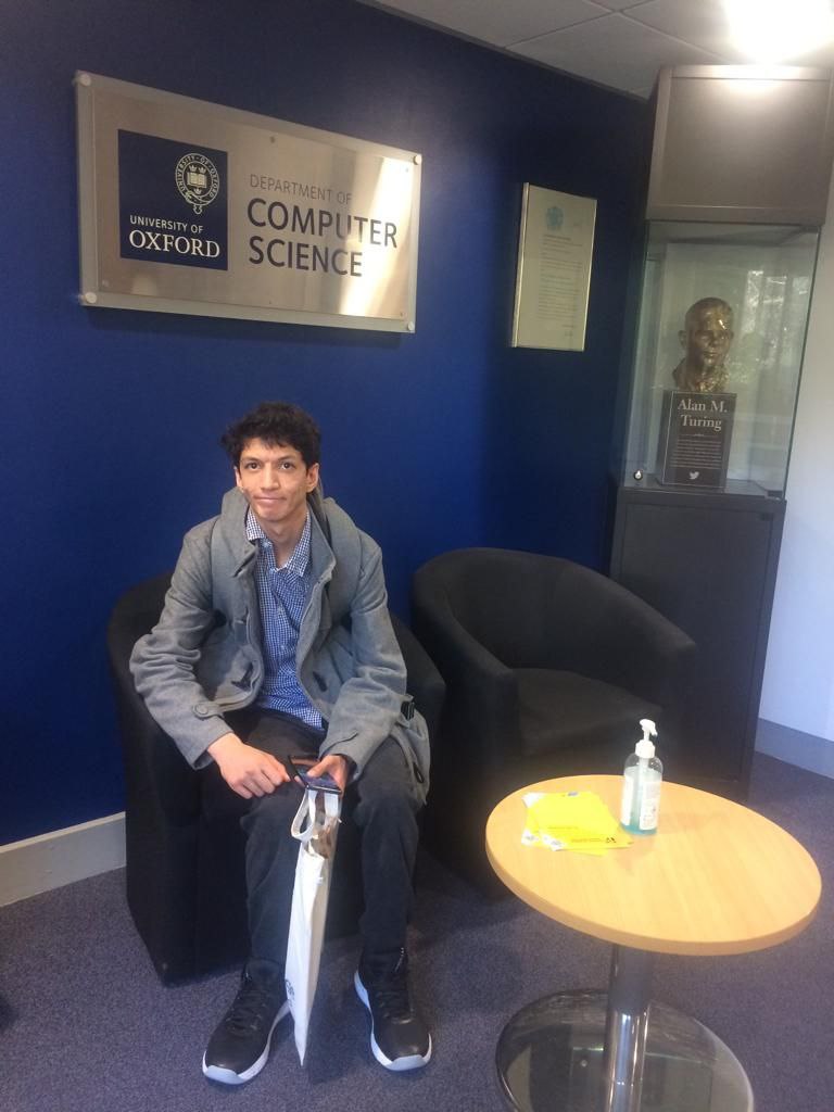 Sitting down in the Computer Science department at the University of Oxford near an Alan Turing statue.