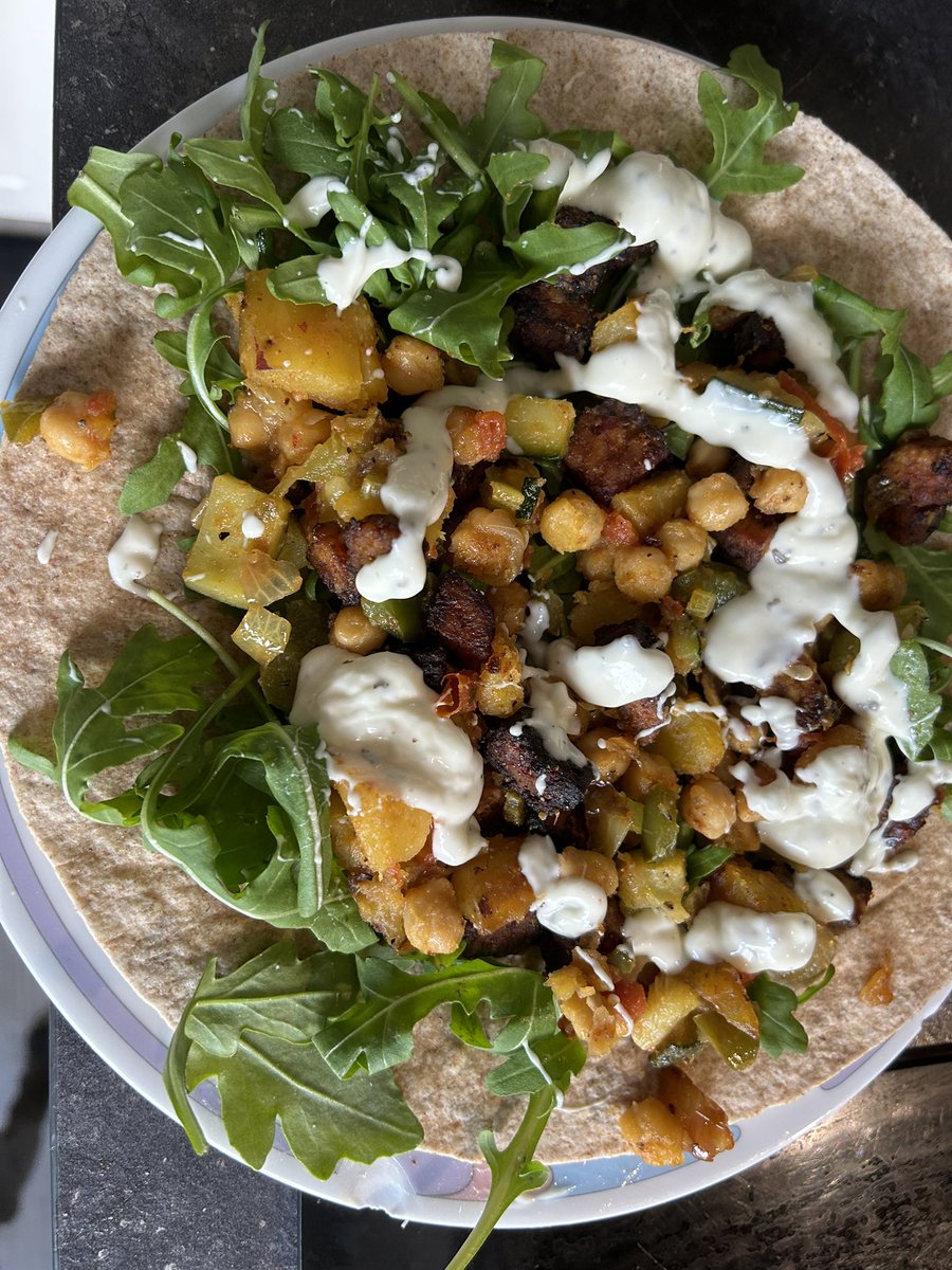 Wrap met rucola. Mix van cajun kruiden, knoflook, zoete aardappelen, tempeh, kikker erwten, courgette en aubergine. Mmmmmm yummie