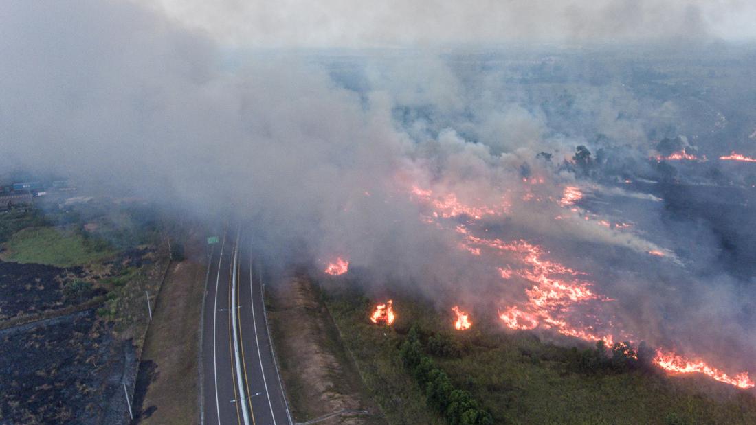 CNNIndonesia's tweet photo. Kebakaran melanda lahan di Desa Sungai Rambutan, Ogan Ilir, Sumatera Selatan, sejak Kamis (14/9) malam. Api dan asap mengepung Jalan Tol Trans Sumatera ruas Palembang-Indralaya. Angin kencang membuat petugas kewalahan untuk memadamkan api. https://t.co/H3b25zkgaW #CNNIndonesia https://t.co/sRXJY4RMZ2