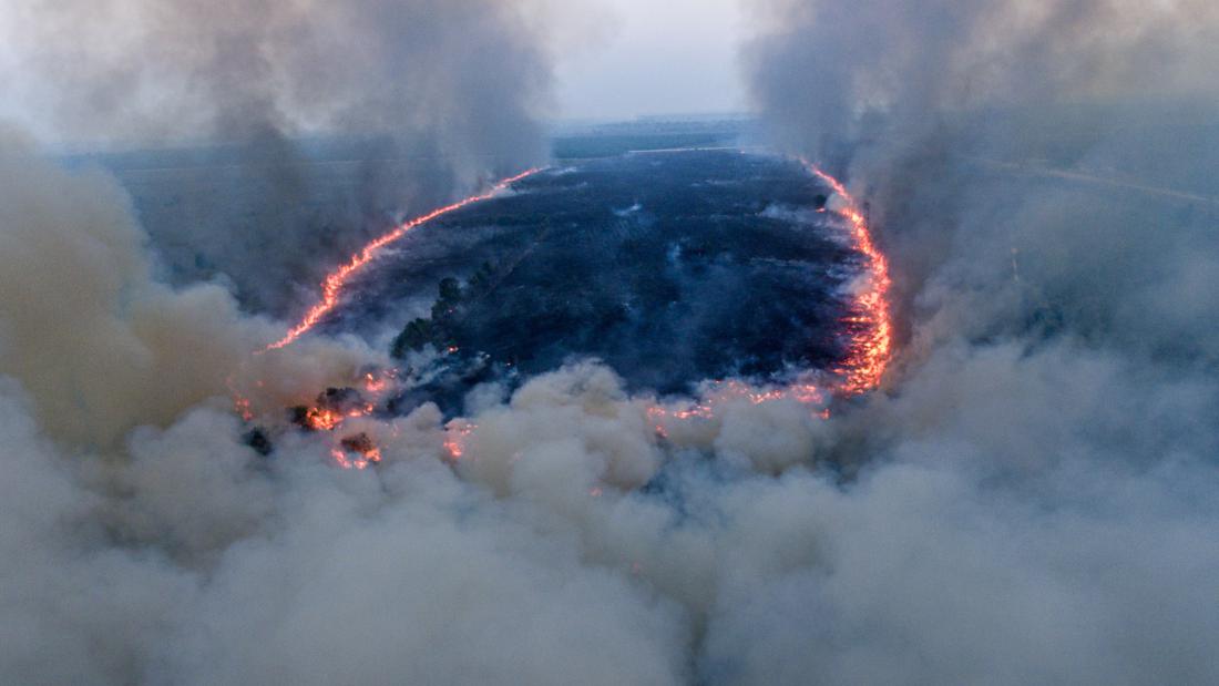 CNNIndonesia's tweet photo. Kebakaran melanda lahan di Desa Sungai Rambutan, Ogan Ilir, Sumatera Selatan, sejak Kamis (14/9) malam. Api dan asap mengepung Jalan Tol Trans Sumatera ruas Palembang-Indralaya. Angin kencang membuat petugas kewalahan untuk memadamkan api. https://t.co/H3b25zkgaW #CNNIndonesia https://t.co/sRXJY4RMZ2