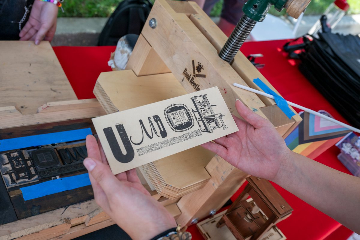 UMDEnglish's tweet photo. Bookmark printing with @umd_BookLab at #NextNOWFest 2023! Participants used a letterpress modeled on the historic Gutenberg screw press to create hand-printed bookmarks. Shout out to the amazing BookLab and @TheClariceUMD teams for making this activity possible. #ArtsForAll https://t.co/jGpOuypgBP