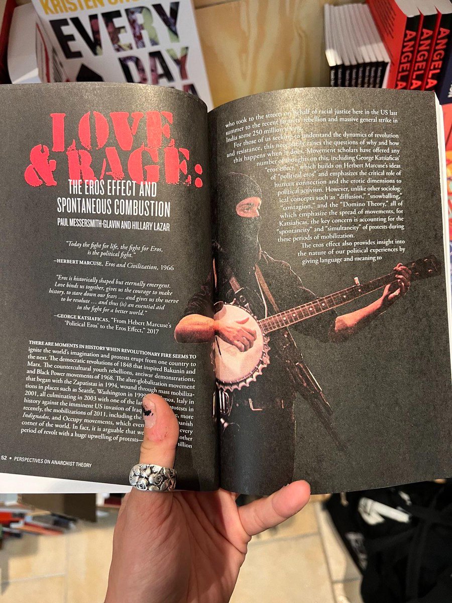 Spotted by a comrade in an anarchist bookstore in Berlin! The current "Transformations" issue of Perspectives on Anarchist Theory! (photo of a Portland protestor with an AK-47 slung over their shoulder playing a banjo by <a href="/MaranieRae/">Maranie R. Staab</a> )
