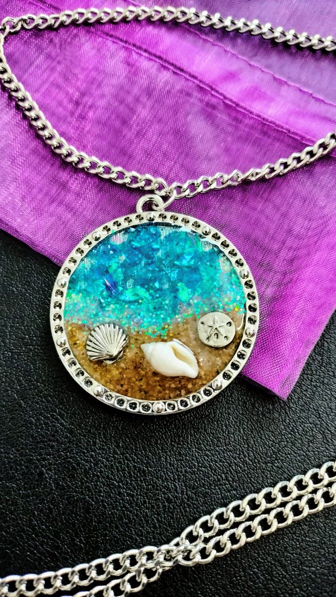 Take the beach with you and relax anywhere! Made with seashell charms, real seashell and real sand in resin. shopuniquecreations.com #handmade #handmadejewelry #resinjewelry #beachjewelry #beach #seashelljewelry