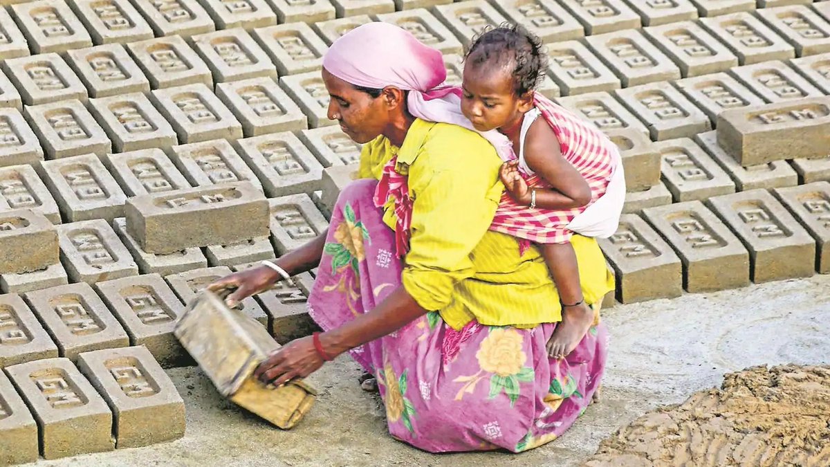 Женщина несет своего ребенка верхом на спине во время изготовления кирпичей в печи для обжига. Южный Динаджпур — округ в индийском штате Западная Бенгалия. 7 марта, 2022 года. (Фото: PIB)