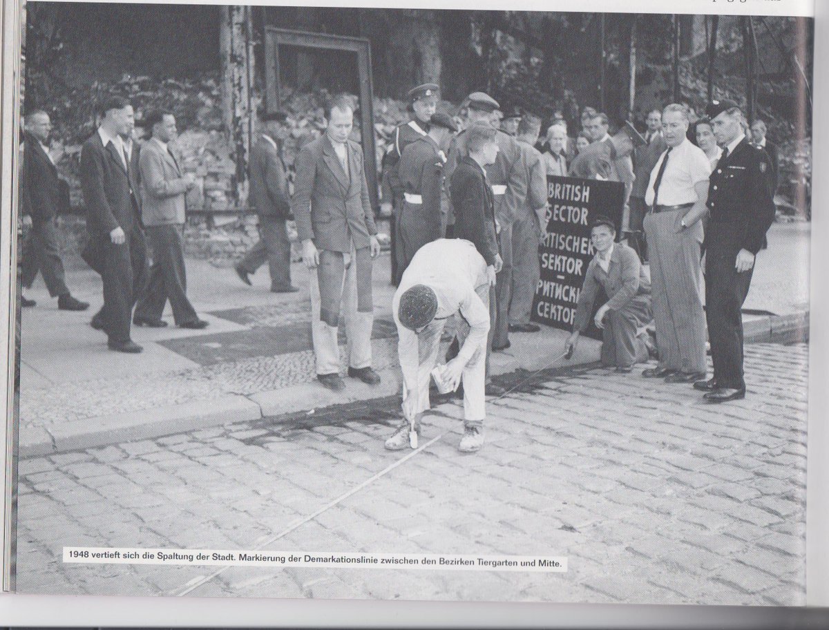 In 1948 a line is drawn between the East and West sectors of Berlin, where, 13 years later, the Wall was built. Their amused expressions suggest the onlookers had no idea what lay ahead. (Photo from Thomas Flemming &amp; Hagen Koch, 'Die Berliner Mauer', Berlin 2001)