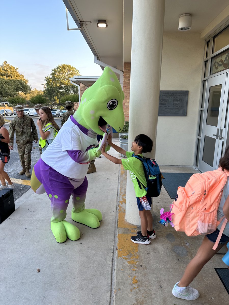 CAMO the Chameleon, the @PurpleUpUSA Military Mascot, was at Woodridge this morning along with our AHHS Army JROTC cadets! Together they greeted & high-fived students as they arrived! We love to see the celebration of our military families here in AHISD! 💛💜💙 #NoPlaceLikeAHISD