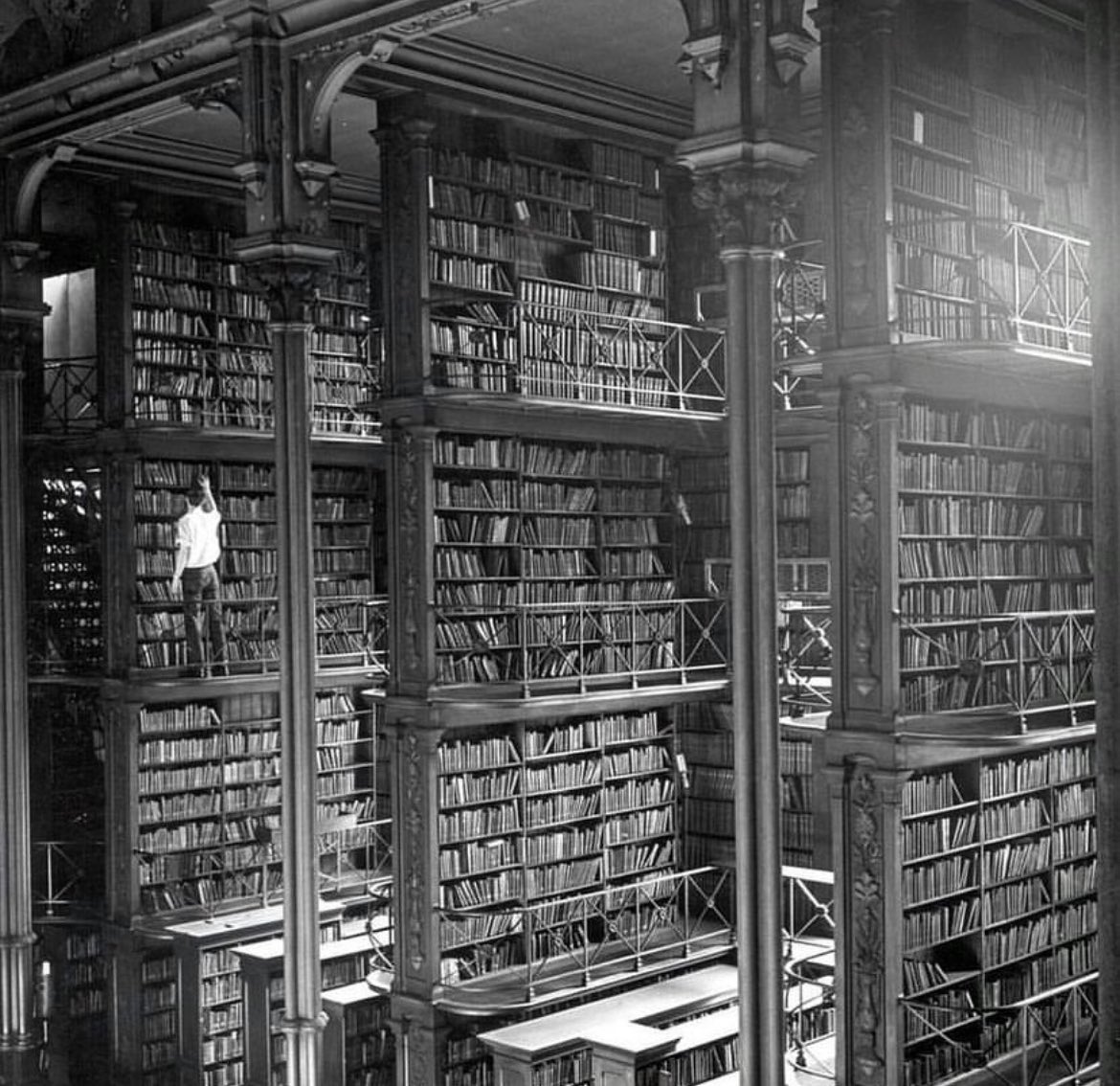 historyinmemes's tweet photo. A man browses for books in the old Public Library of Cincinnati. The building was demolished in 1955. Today, an office building and a parking lot stand where it used to be.

The Old Cincinnati Library was built in 1874 on the site reserved for an opera house. With five levels of cast iron shelving, a fabulous foyer, checkerboard marble floors, and an atrium lit by a skylight ceiling, the place was considered a great architectural work. The cost of the lot and building was $383,594.53, about $7.7 million today. The Public Library contained 60,000 volumes, with an estimated capacity of 300,000.

The reasons why the building was demolished were poor ventilation, stuffy air, peeling paint, and at a certain point, the book collection had started to outgrow the building, and books were stacked beyond reach.