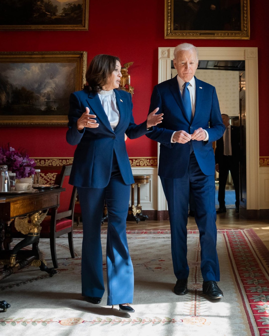 President Joe Biden talks with Vice President Kamala Harris in the Red Room of the White House.