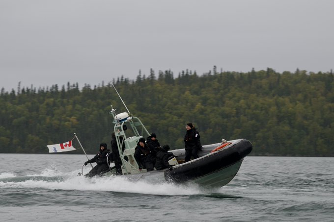 Des membres du NCSM Carleton effectuent un exercice naval sur un petit bateau. 