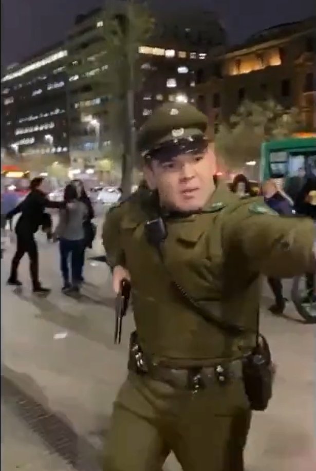PiensaPrensa's tweet photo. Funcionario de @Carabdechile sin identificación amenazó con revolver en mano a manifestantes que se encontraban en la vereda en pleno centro de Santiago, calle Arturo Prat con Alameda. Otros tres  oficiales tambien desenfundaron armas y golpearon a  mujeres.
via @Murosyresisten https://t.co/QKTYeIeIvb