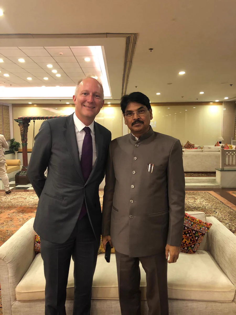 Sam Townend KC and Manan Kumar Mishra standing together smiling in a conference centre.