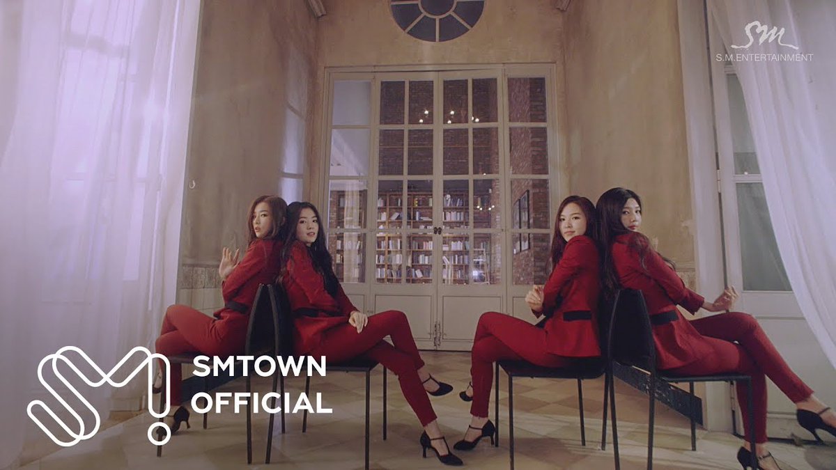 SMTOWN OFFICIAL promotional image featuring four women in matching red outfits posing on chairs in an elegant room with tall windows, with 'S.M. ENTERTAINMENT' logo visible.