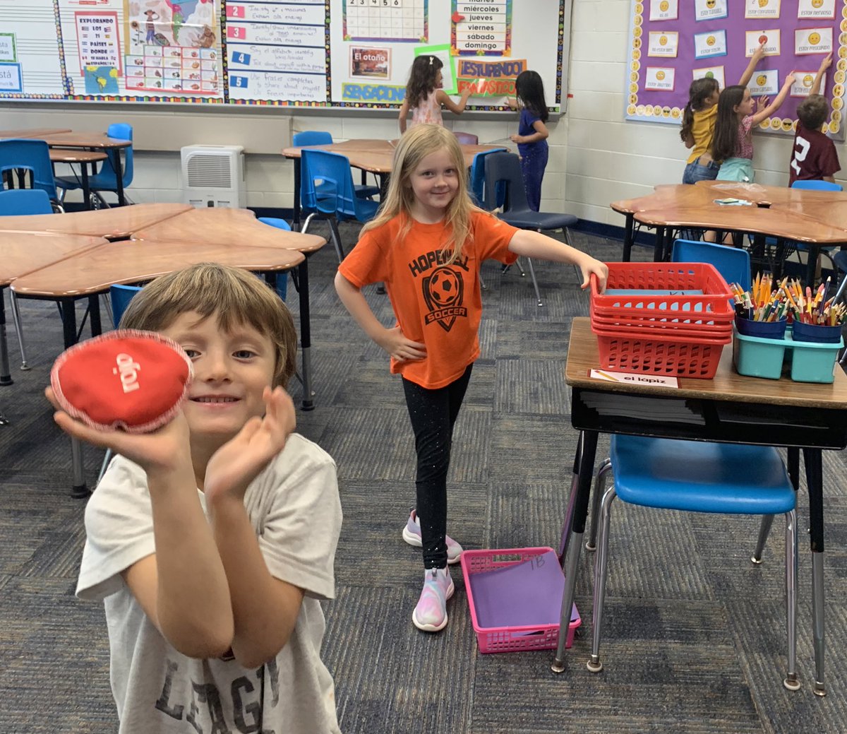¡Toca algo rosa! Touch something pink! 1st grade estudiantes spin the “Wheel of Colores” and find them all around our Spanish classroom! #beartavernpride