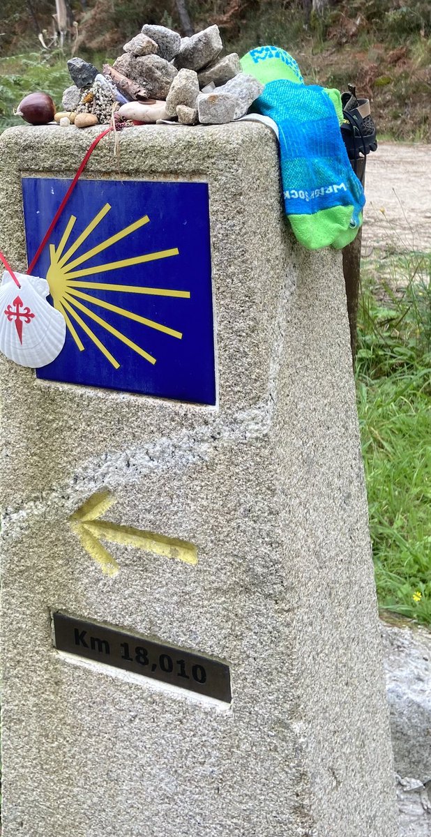 the final 17 Kms of my #CaminoPaddyMoloney to #SantiagodeCompostela The mileage markers sprinkled with pebbles, shells, & ‘conkers' for personal journeys, now replaced with old hiking shoes and smelly socks. Jayz, coulda done with a 2nd pair of shoes at 275 km mark :) 💚