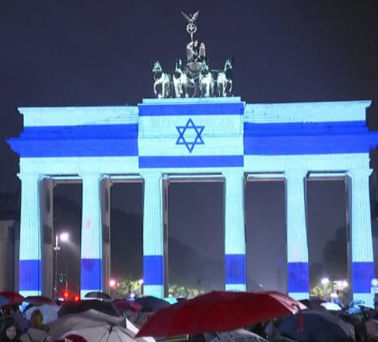 eugyppius1's tweet photo. Left: The Brandenburger Tor in Berlin, illuminated in Israeli colours in expression of solidarity after the Hamas attacks.

Right: Pro-Palestinian activists in the Berlin Neukölln neighbourhood celebrate the "resistance of the Palestinian people"

This is Germany now https://t.co/Vmnnj3SEPj