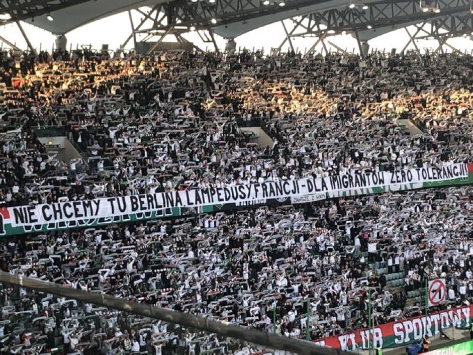 AmyMek's tweet photo. Poland First! 

Football fans in Warsaw today send a message to the corrupt EU who is trying to force Poland to take in illegal migrants, and put their citizens at risk: 

“We don't want Berlin, Lampedusa, or France here - Zero tolerance for immigrants!" https://t.co/1P0Cq1dONA