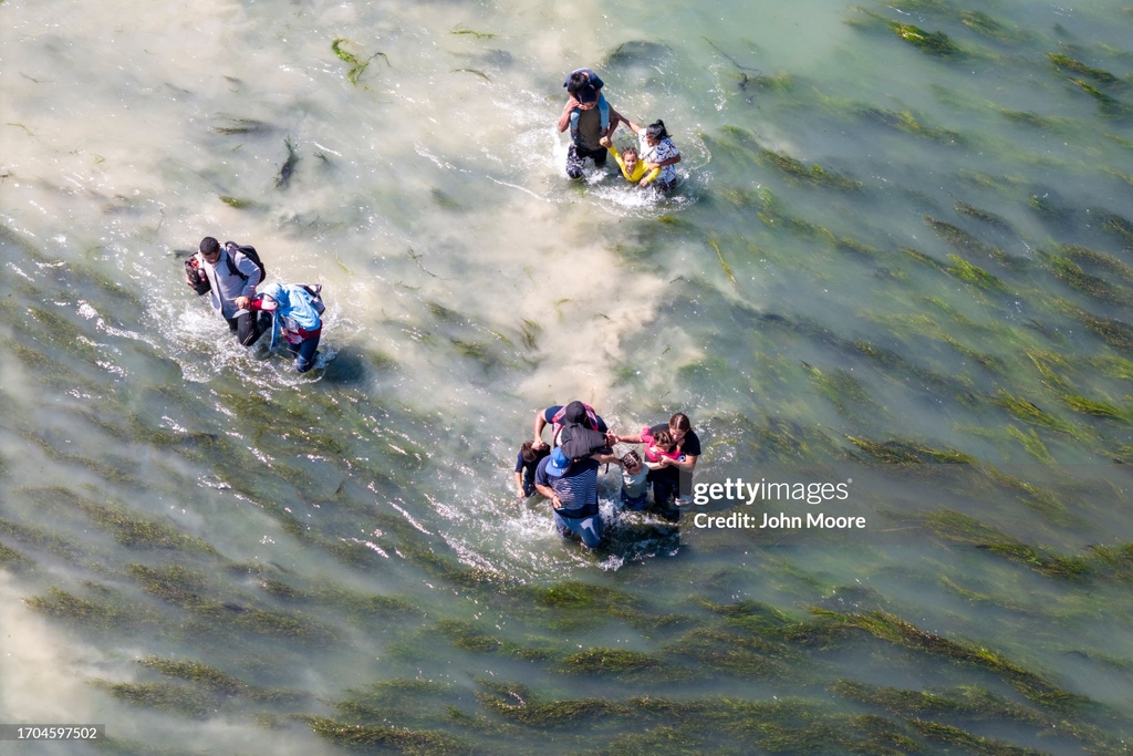 GettyImagesNews's tweet image. Immigrants cross the Rio Grande from Mexico into the U.S. as Border Patrol agents look on in Eagle Pass, Texas. A surge of asylum-seeking migrants has put pressure on U.S. immigration authorities, reaching record levels in the last week. 📷️: @jbmoorephoto #immigration #USborder