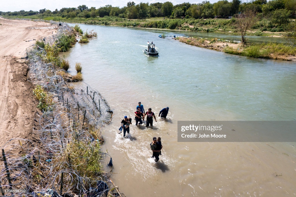 GettyImagesNews's tweet image. Immigrants cross the Rio Grande from Mexico into the U.S. as Border Patrol agents look on in Eagle Pass, Texas. A surge of asylum-seeking migrants has put pressure on U.S. immigration authorities, reaching record levels in the last week. 📷️: @jbmoorephoto #immigration #USborder