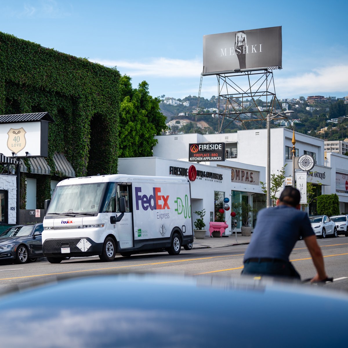 DavidGanske's tweet photo. @zeta_2030 is encouraging everyone to capture photos of #EVsInTheWild as part of #NationalDriveElectricWeek. Today, I saw one of the many electric @FedEx delivery vans around LA provided by @brightdrop. If you look closely, there are actually two other #EVs in this photo. https://t.co/EMFjtfJ0QZ
