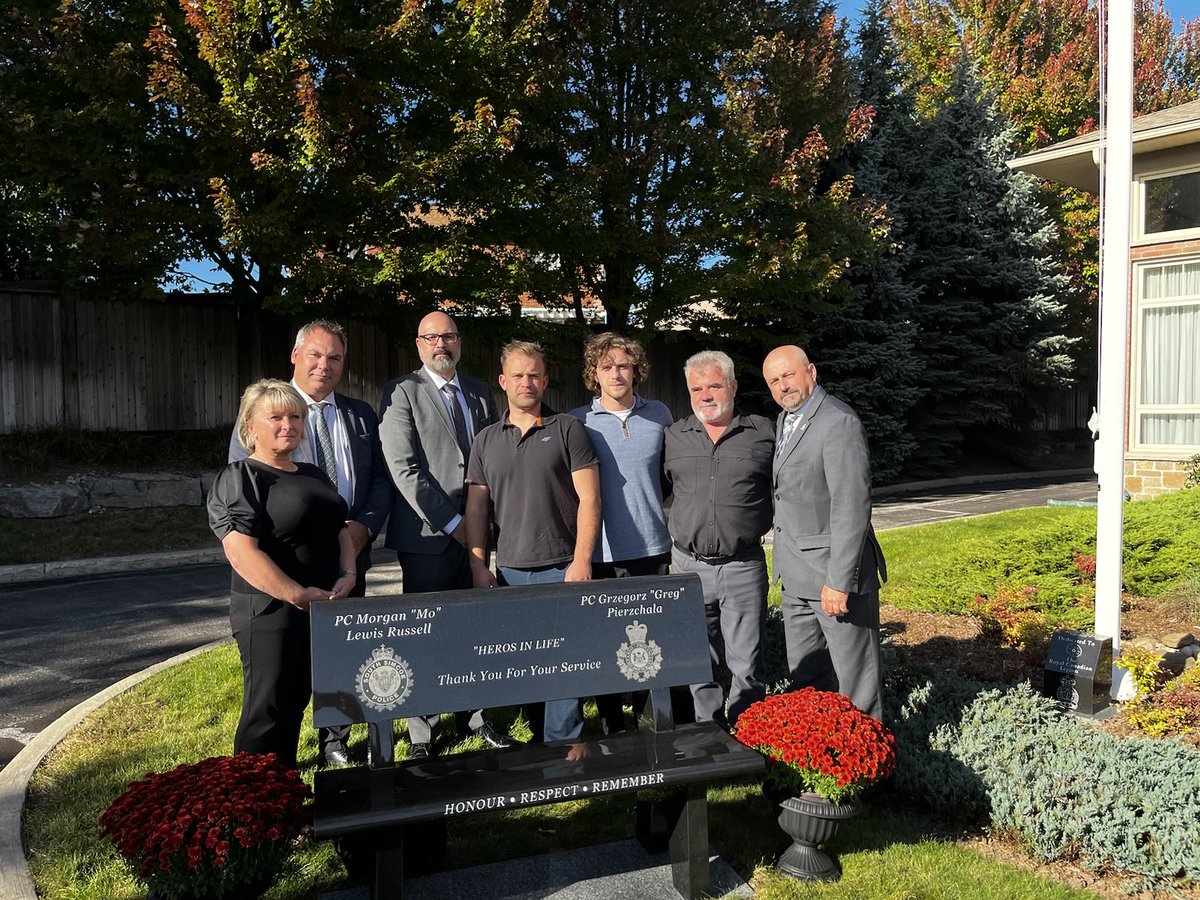 OPPAssociation's tweet photo. The OPP Association are grateful to Adams Funeral Home in Barrie Ontario for the memorial bench unveiled in front of their funeral home honouring OPP Provincial Constable Greg Pierzchala and South Simcoe Constable Morgan Russell. Always remembered. #HeroesInLife https://t.co/D32BPzWWg7