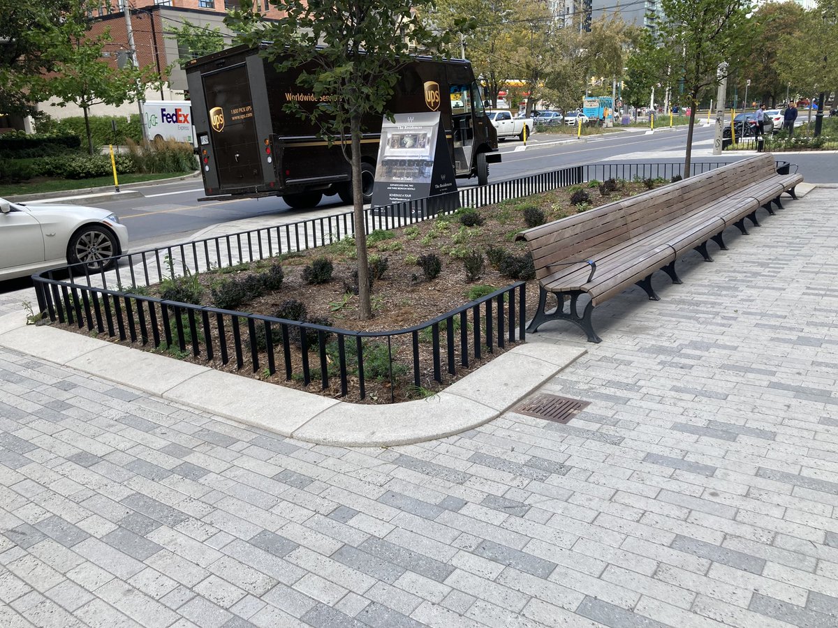 Admiring the wide sidewalks, generous planters, and long benches along Wellington Street West, next to The Well.
