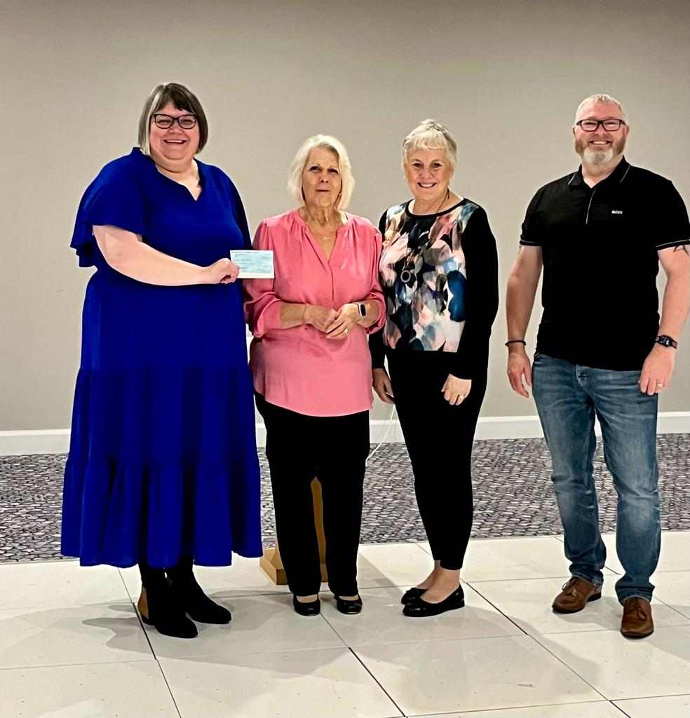Helping in the community. Cheques for Love Oliver and John Fegus School