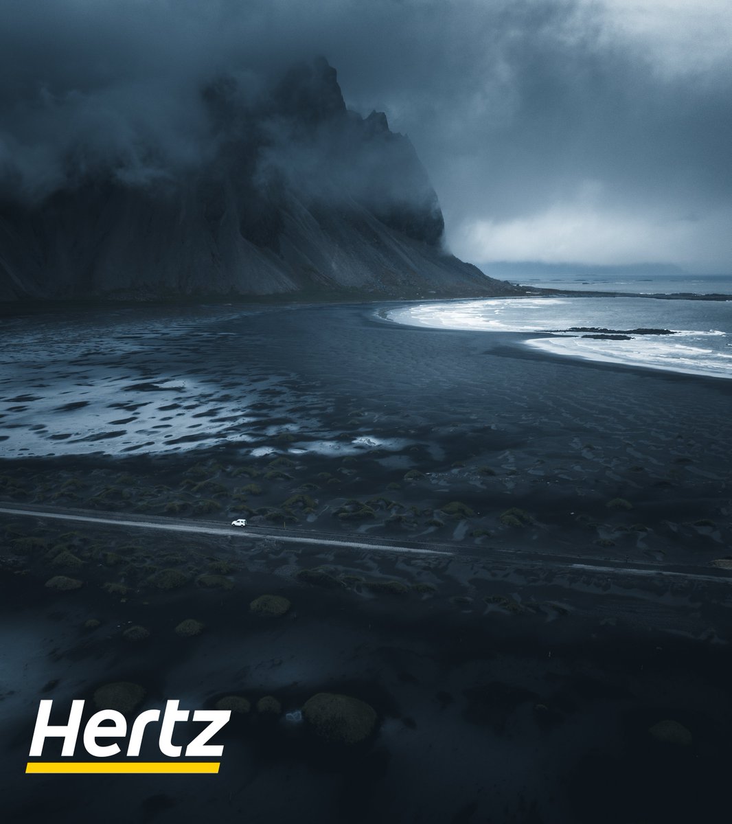 Driving through nature's masterpiece, where dark blue mountains whisper secrets to the serene beach. Every journey here is a passage through poetry written by the earth. Who else is ready to listen? 🌌🌊🚗