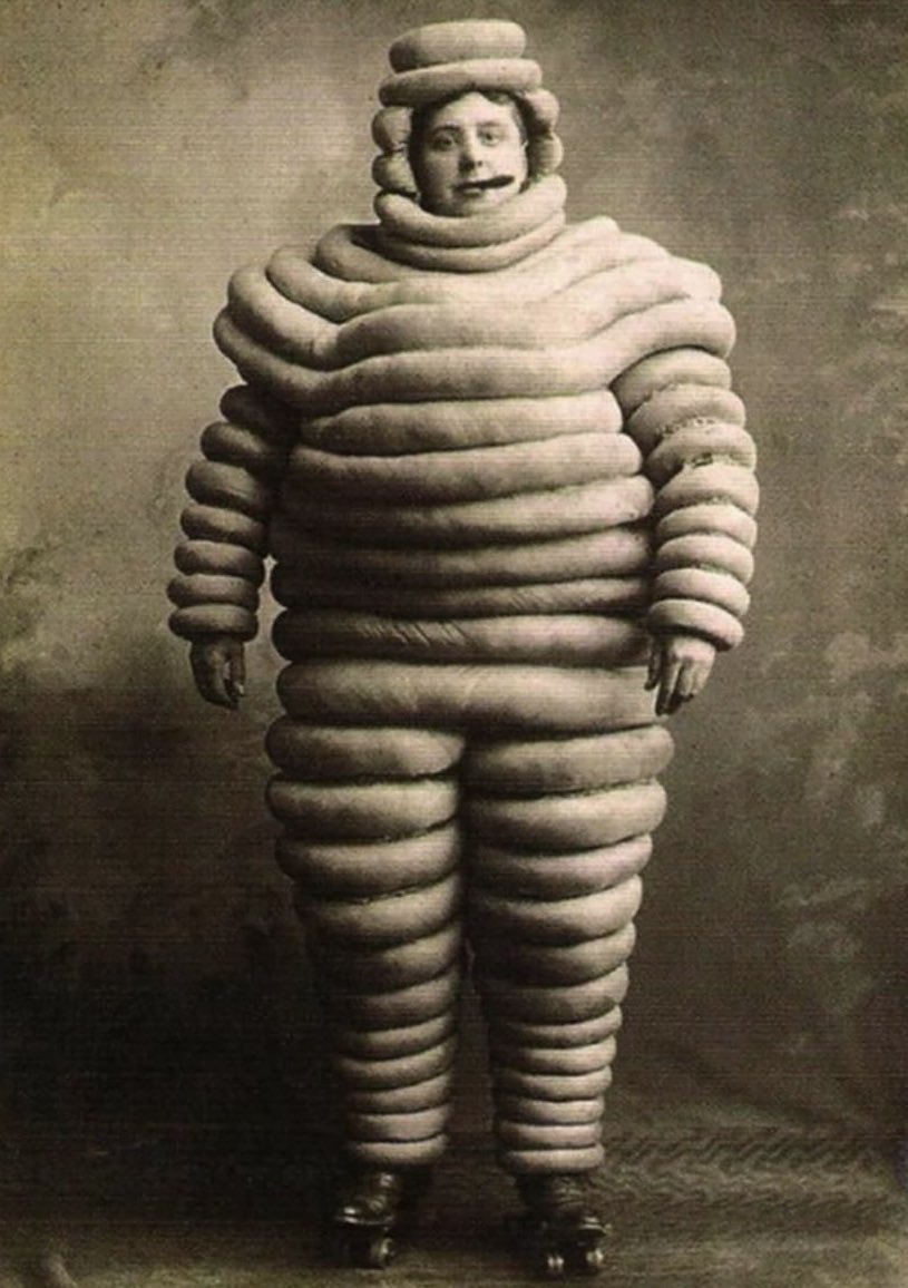The original Michelin Man from 1894. He was is white because rubber tires are naturally white. It was not until 1912 that carbon chemicals were mixed into the white tires, which turned them black. The change was structural, not aesthetic. By adding carbon, tires became more