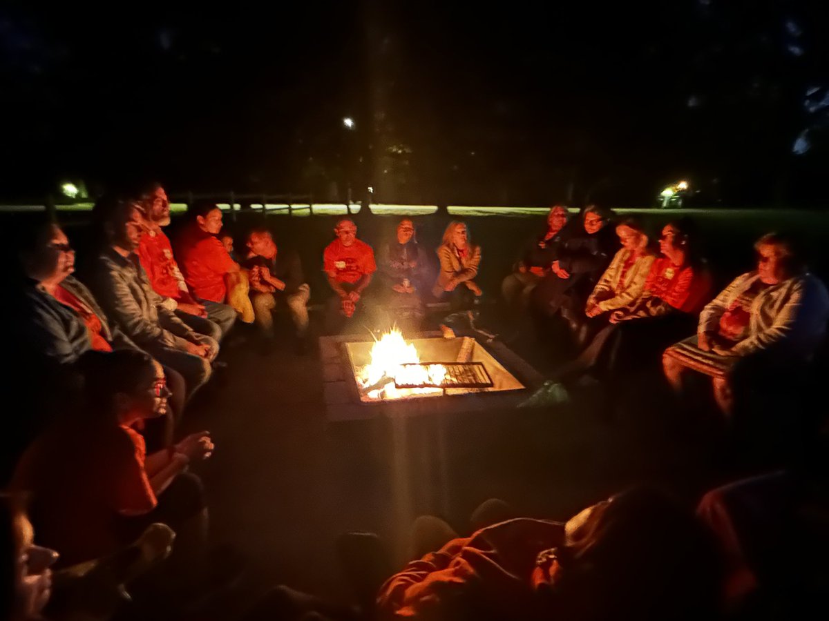 Participants at the Indigenous Clinicians Gathering are gathered around the fire for storytelling time. #NDTR2023