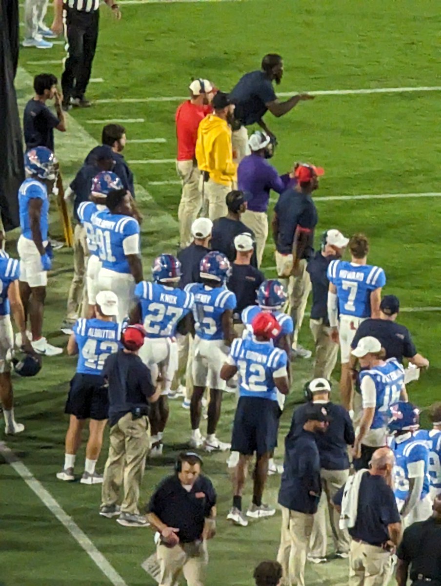 JenGreer1's tweet photo. For this game they could have picked different color shirts for the coaches... purple and yellow are not a good look today #OleMiss #hottytoddy @OleMissFB https://t.co/MEZp9cCFeF