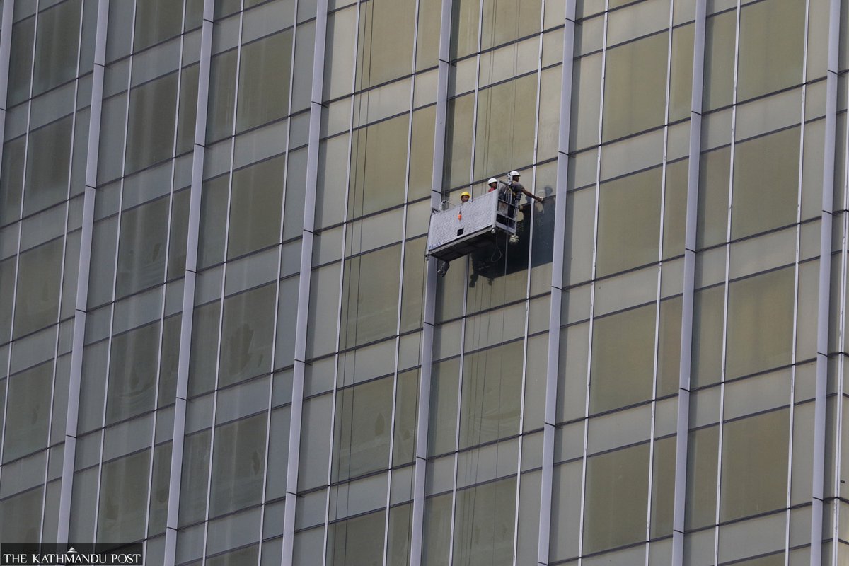 Workers clean up the glasses of a newly constructed building at Kantipath, Kathmandu, on Friday.

Photo by: <a href="/Thapakeshav7/">keshav thapa</a>
