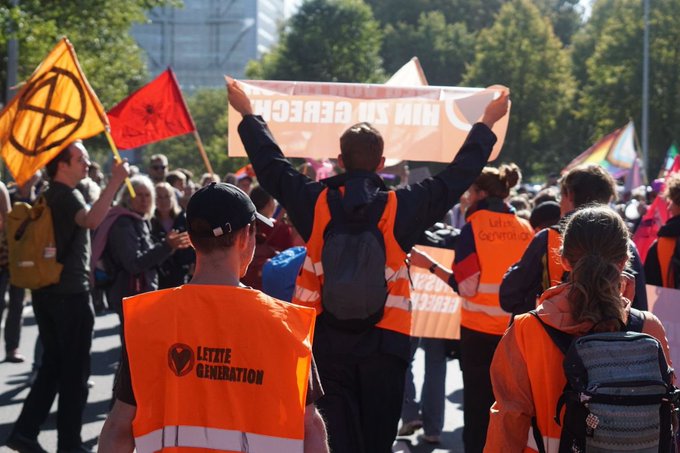 Letzte Generation in DenHaag auf der Straße. Sie tragen Warnwesten.