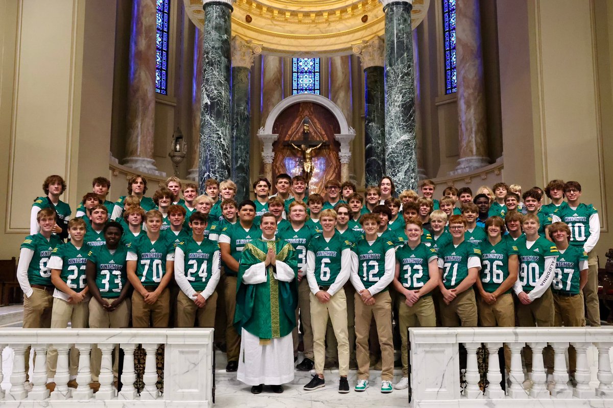 OGorman football team and families attend Sunday Mass at the Cathedral with Fr Tony Klein.   Team wore Cathedral green uniforms to honor Cathedral High’s tradition.