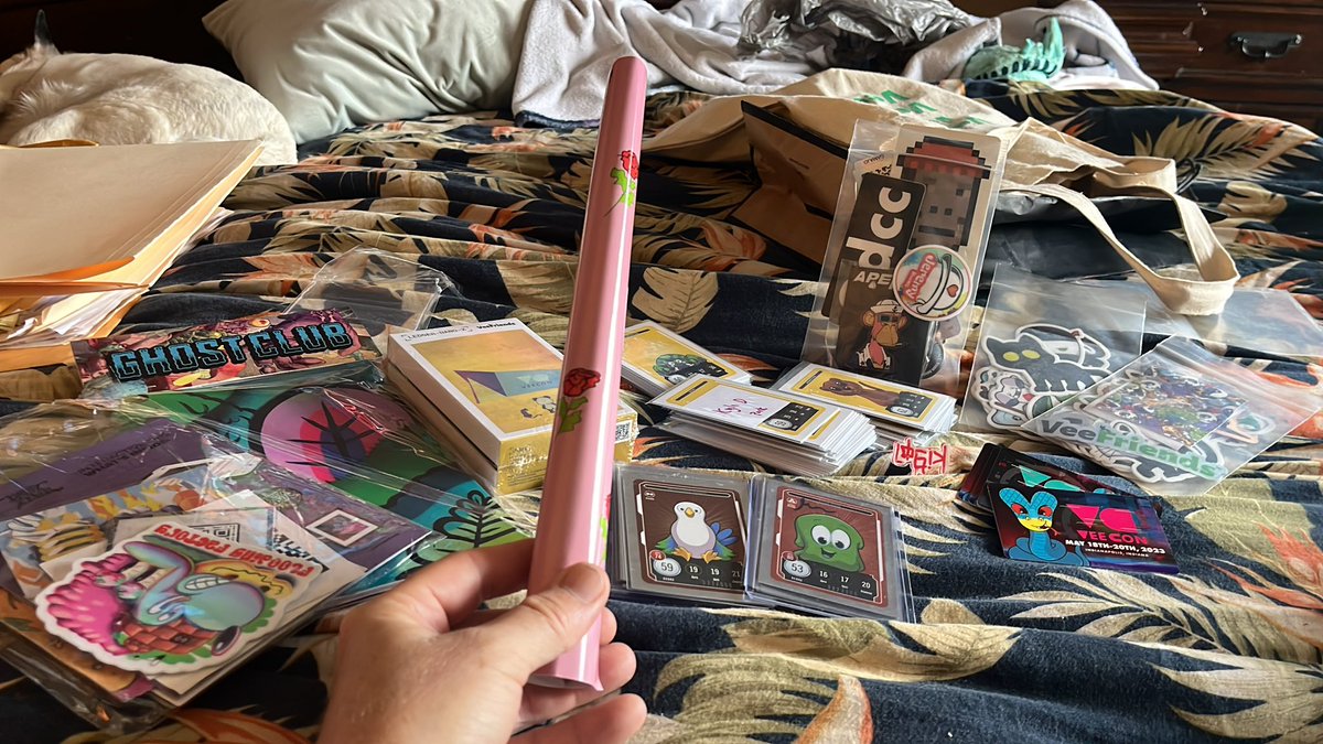 MetaFinzTD's tweet photo. @veerose_eth going through conference bags and found a #veerose @KATZNESS I have a decision, should I open it or gift it to someone? And some other notable memorabilia from OGs. @gmoneyNFT @Legend @jeremyknowsVF @JulianGilliam @mumbot @garyvee https://t.co/KbtxKEciZd
