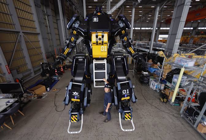 CEO Ryo Yoshida poses for a photograph with ARCHAX, a giant human-piloted robot developed by his start-up Tsubame Industries Co., in Yokohama, south of Tokyo, Japan September 27, 2023. REUTERS/Issei Kato