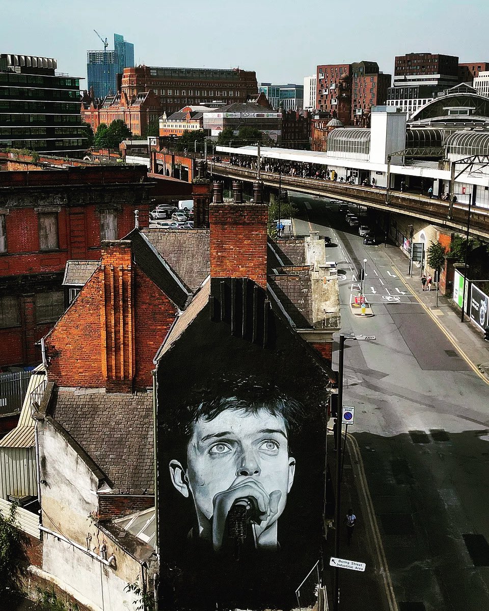 Here is a photo of the new spot for the iconic Ian Curtis mural! 🎨 Join us as we pay tribute to the legendary Joy Division frontman with our rendition of 'Love Will Tear Us Apart' 🎶 Listen here: lnk.to/UHLoveWillTear…