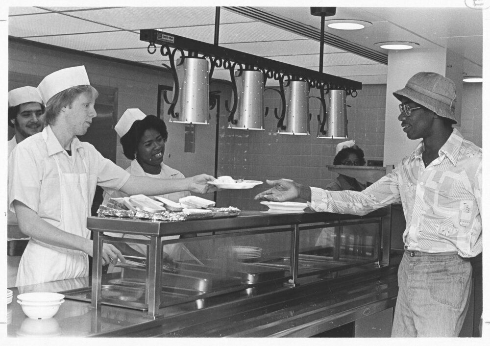 Flashback to the taste of nostalgia in September 1976! 🍔🕰️ Our campus cafeteria crew always knew how to serve up smiles along with the food. 😄🍽️ #ThrowbackThursday #TBT #CampusCafeteriaChronicles #MemoriesOnMyPlate #UAlbany #UAlbanyLibraries #UniversityArchives