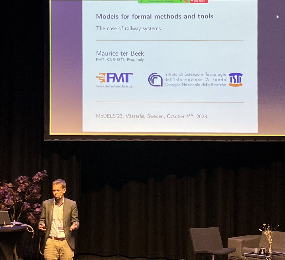 seidewitz's tweet photo. Maurice ter Beek from the Formal Methods and Tools Lab at CNR-ISTI begins his keynote at #models23 on “Models for formal methods and tools: The case of railway systems”. “This is my first time at MODELS, but I am told you like models.” https://t.co/dQGHm70tWi