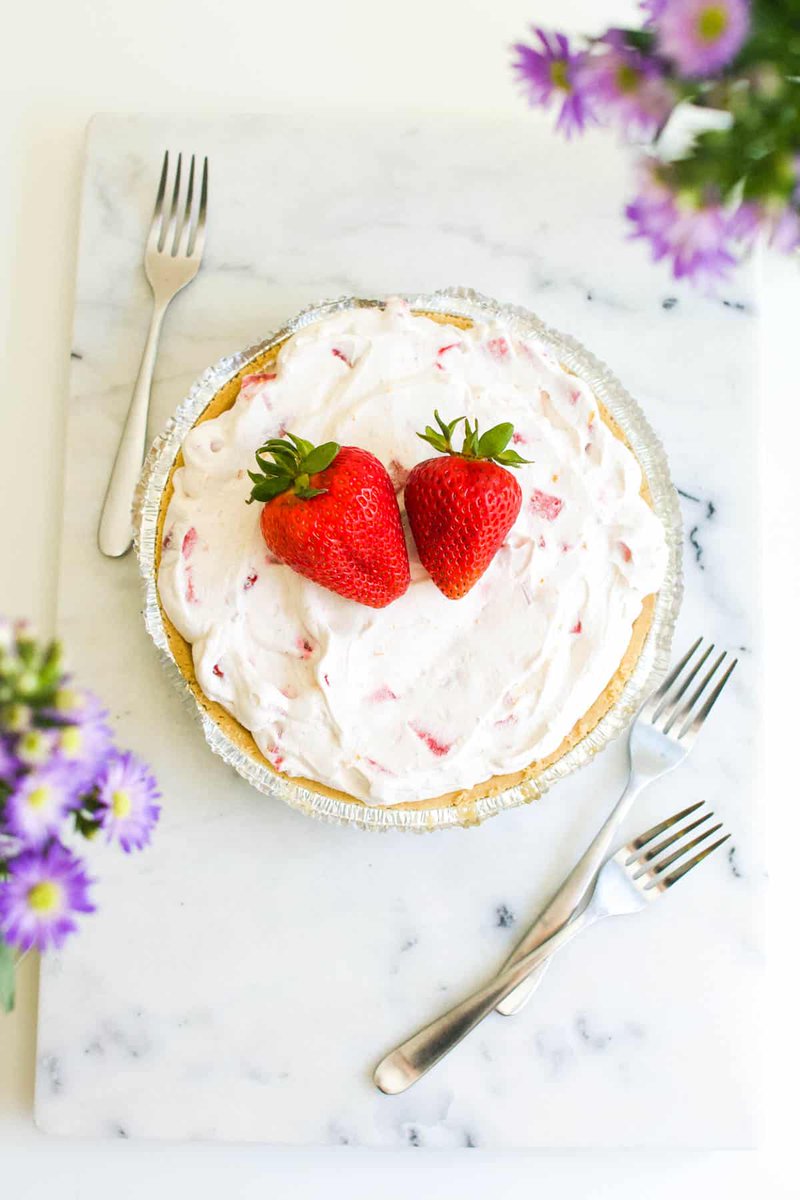 This 5 ingredient Frozen Strawberry Yogurt Pie is a delicious no-bake dessert recipe! Full of berry flavor, this creamy pie is a quick and easy treat to make for friends and family.  cupcakesandcutlery.com/frozen-strawbe…